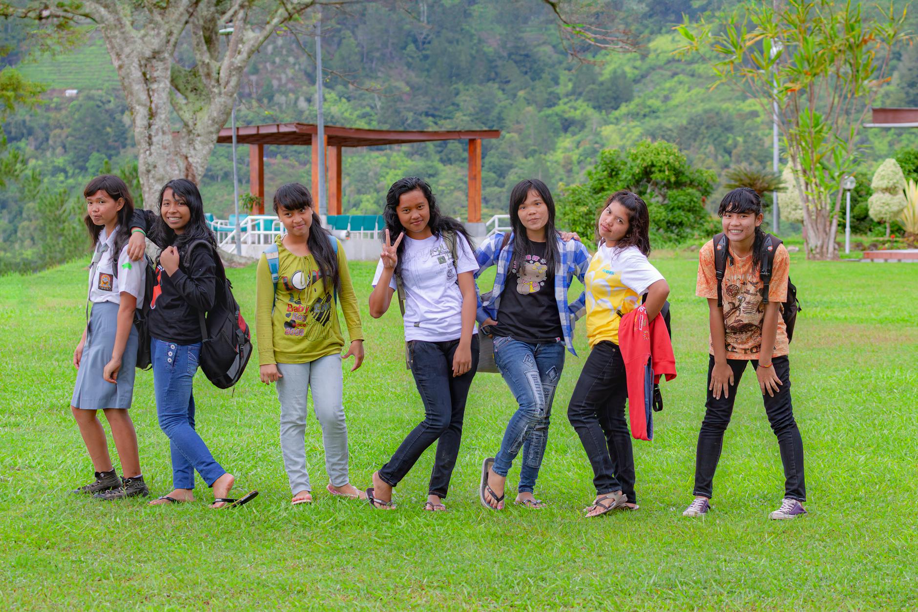 Studentki w Indonezji pozują radośnie na tle zielonego krajobrazu